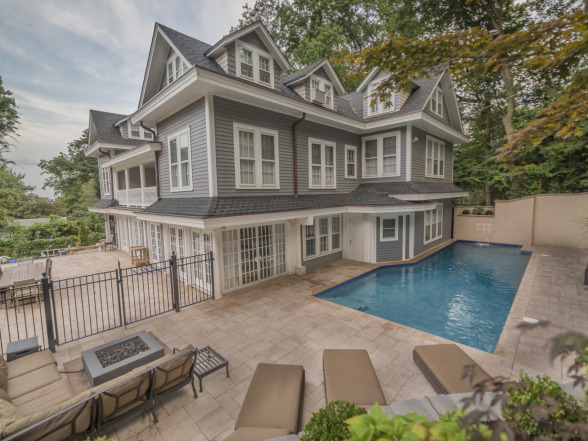 After photo of a completed pool project with paver patio and residential home