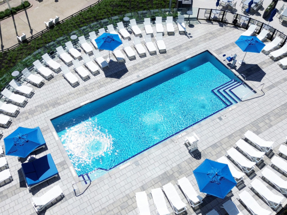Aerial view of the commercial pool showing the full deck layout with lounge furniture and waterfront setting