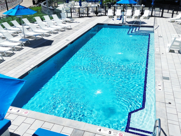 Elevated perspective of the commercial gunite pool with Blue Quartz plaster and paver deck surrounded by high-rise buildings