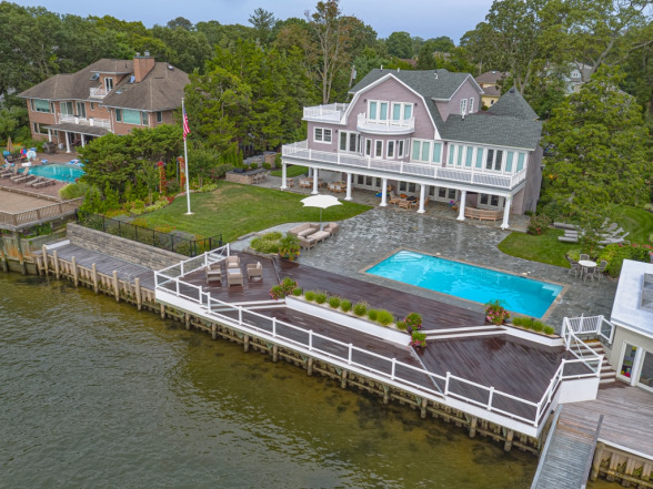 Aerial view of a residential property in Point Pleasant, NJ, featuring a modern in-ground pool, wooden deck, and landscaped yard, highlighting EverClear Pools & Spas pool construction services.