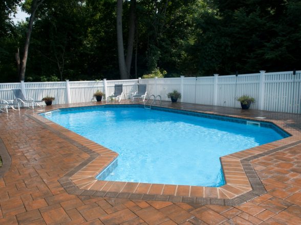 Rear angle of the freeform pool highlighting the geometric coping edge detail and Ledgestone paver patio