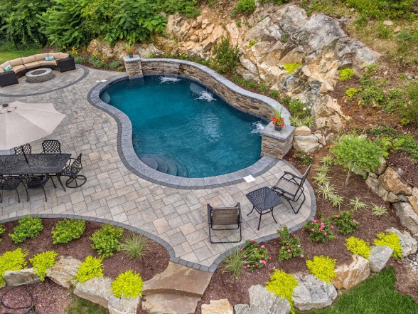 Custom gunite pool with stone accents, surrounded by landscaped patio and seating area, showcasing EverClear Pools & Spas design and construction expertise.